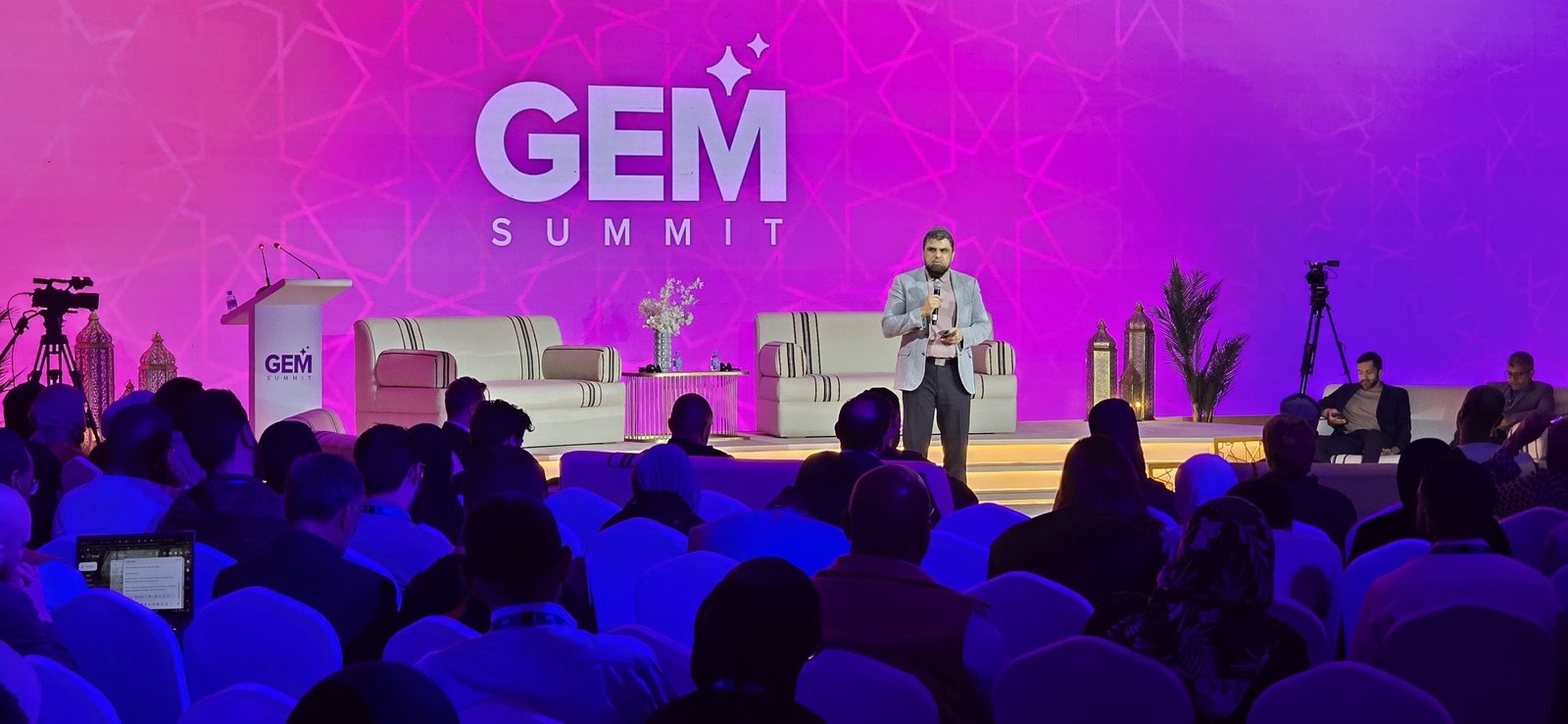 Kashif Shabir speaking on stage to a full audience at the GEM Summit